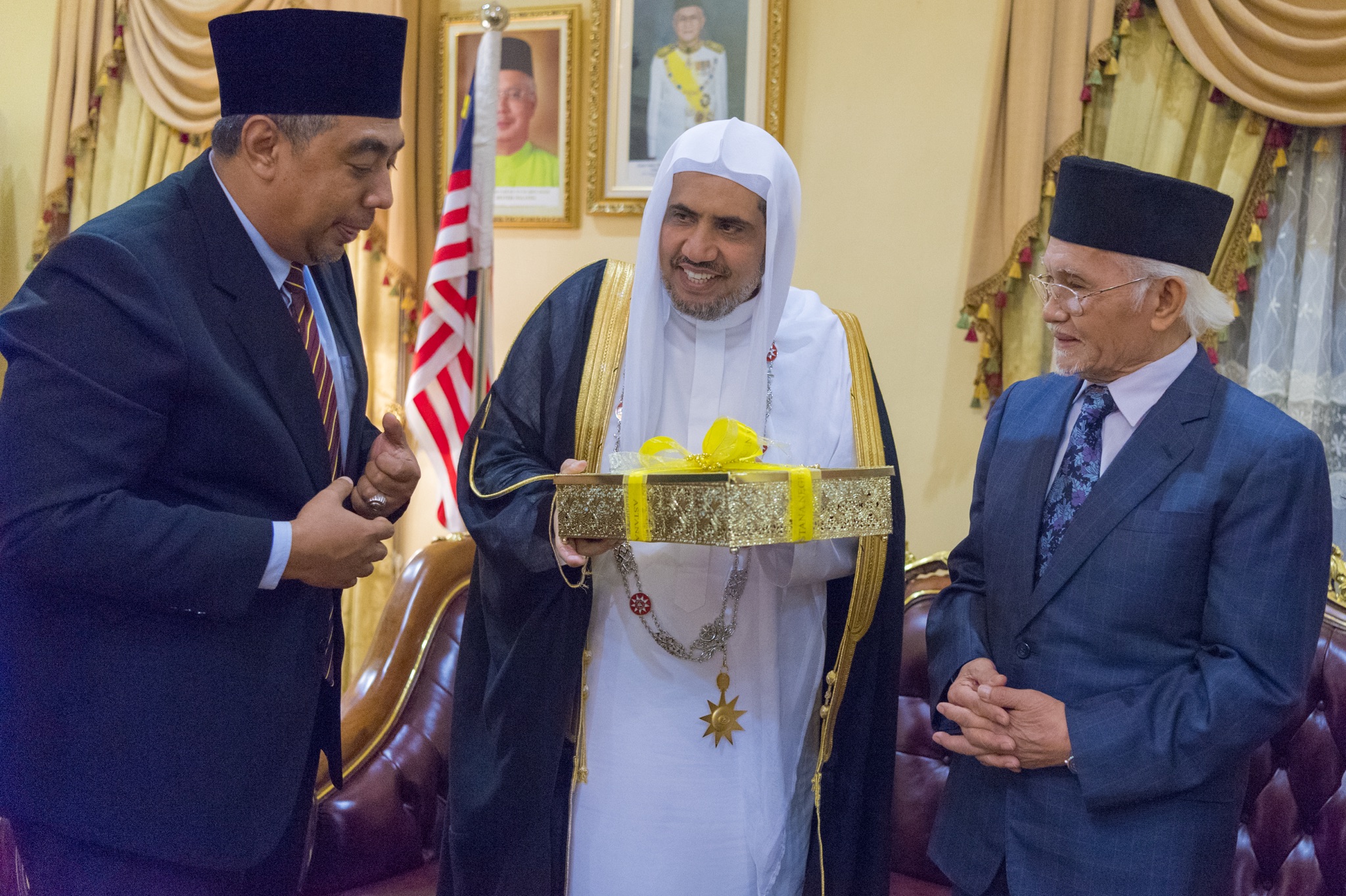 السلطان الماليزي يسلم معالي الشيخ د. محمد العيسى عدداً من الهدايا بعد تقليده الأوسمة