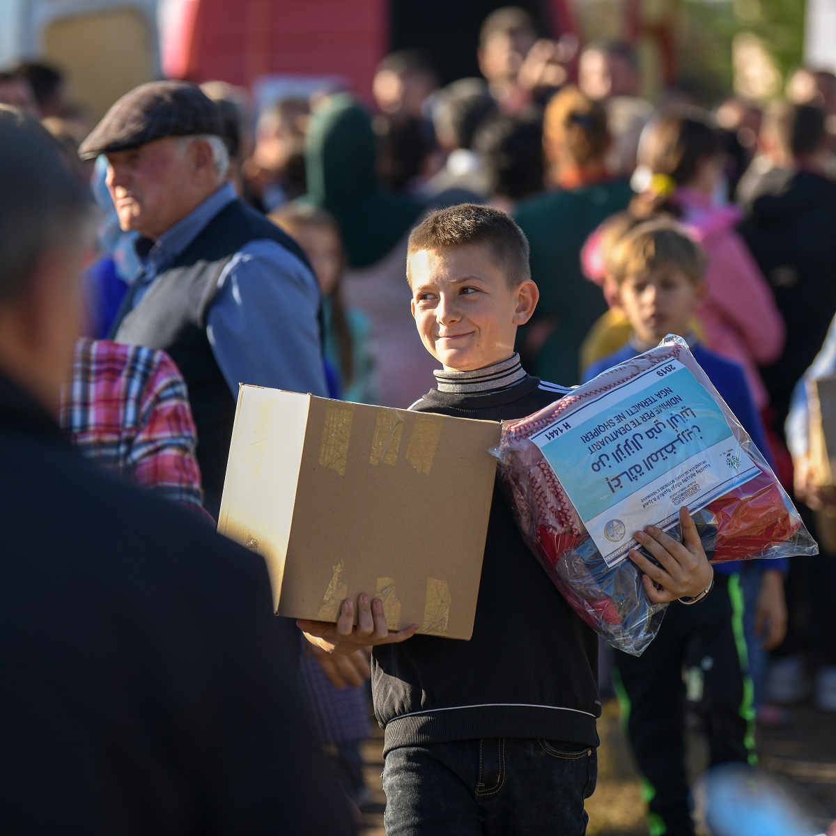 صبي ألباني مبتهج بحصوله على مساعدات الرابطة للمتضررين من الزلزال